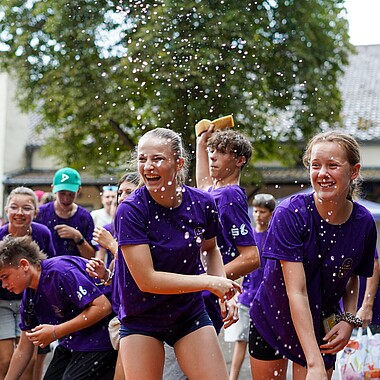 Symbolbild Teilnehmer werfen Betreuer mit Schwamm bei der Betreuerdusche ab beim Tag des offenen Zeltes im Camp Breisach 2026