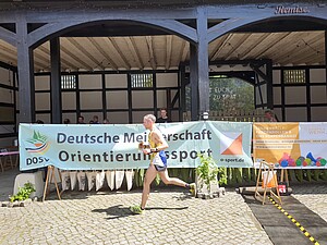 Symbolbild Mann läuft durch Ziel bei Deutschen Meisterschaften Orientierungslauf 2026 in Bündenheim