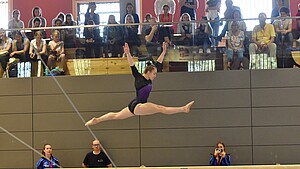 Turnerin im Sprung am Schwebebalken