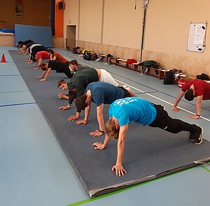 Personen sind in der Plank auf einem Bodenläufer