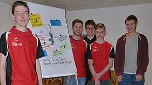 Jugendliche stehen um Plakat