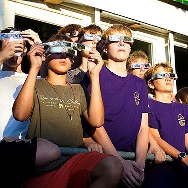 Symbolbild Teilnehmer schauen sich mit Sonnenfinsternis Brille die Sonnenfinsternis an in Camp Breisach 2026