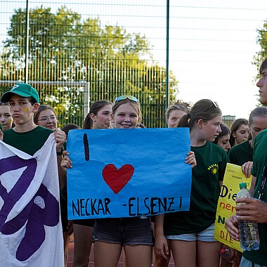 Teilnehmerin mit "I love Neckar-Elsenz" Plakat bei Spiel ohne Grenzen im Camp Breisach 2026