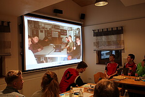 Regio Stammtisch: Personen schauen auf Leinwand