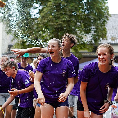 Symbolbild Teilnehmer werfen Betreuer mit Schwamm bei der Betreuerdusche ab beim Tag des offenen Zeltes im Camp Breisach 2026