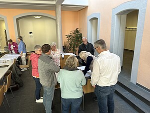 Personen stehen im Kreis und unterhalten sich