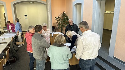 Personen stehen im Kreis und unterhalten sich