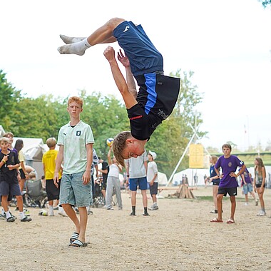 Symbolbild Teilnehmer macht einen Salto auf dem Zeltplatz im Camp Breisach 2026