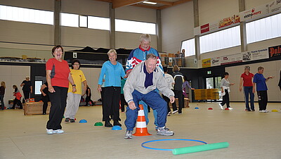 Senioren bewegen sich in einer Sporthalle
