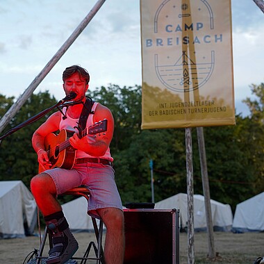 Symbolbild Julian Pförtner singt bei der Lagerfeuerromantik im Camp Breisach 2026